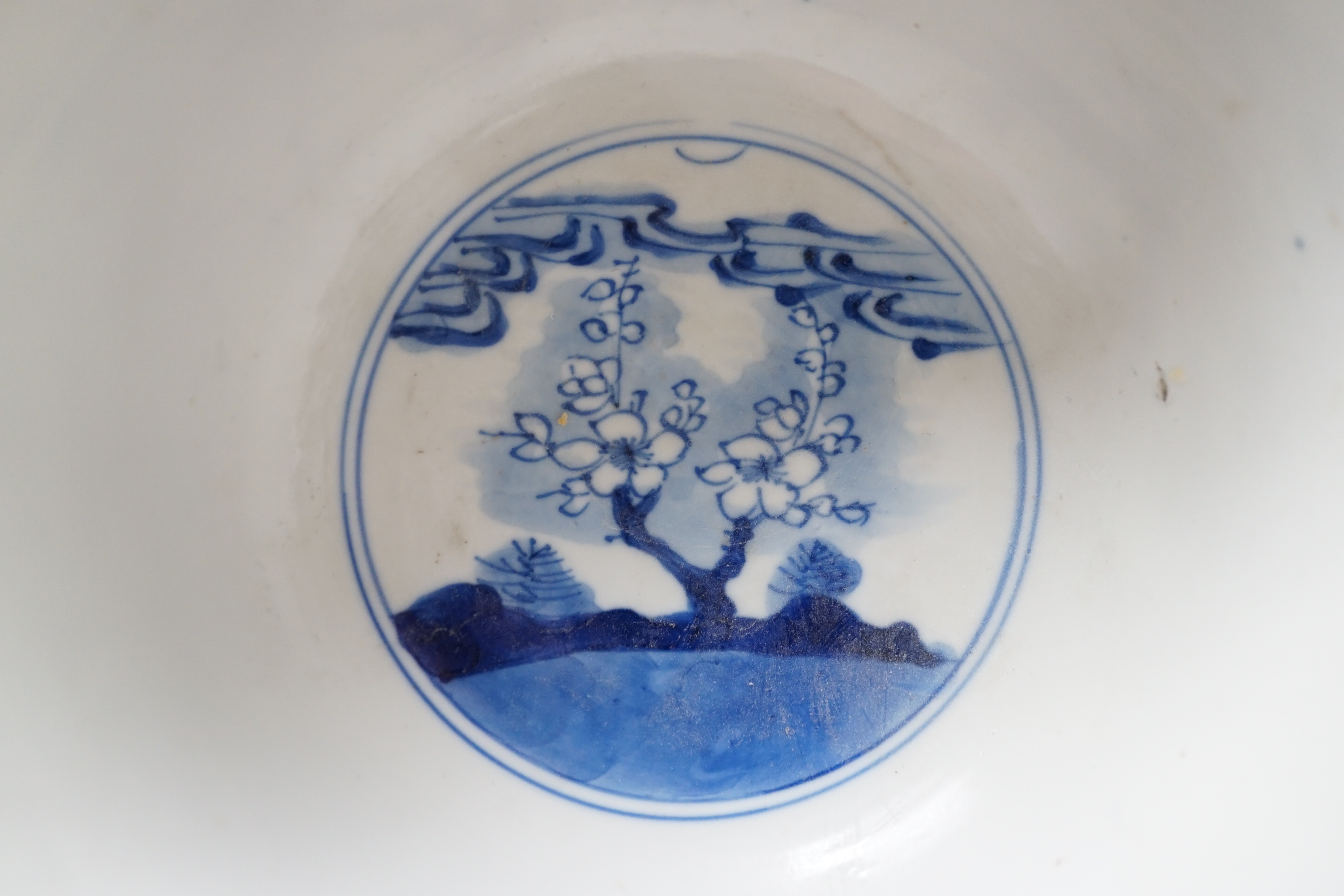 A near pair of Chinese blue and white ‘birds’ bowls, Kangxi period, one bowl restored